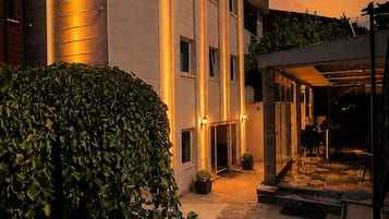 Un hôtel doté d’une entrée bien éclairée, d’un espace extérieur abrité et d’une enseigne indiquant le nom de l’hôtel.