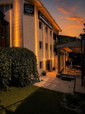 A hotel with a well-lit entrance, a covered outdoor area, and a sign indicating the hotel's name. - Refletion of the Bosphorus (İstanbul)