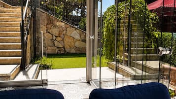 Un intérieur moderne avec une porte vitrée donnant sur un escalier en pierre et un jardin.