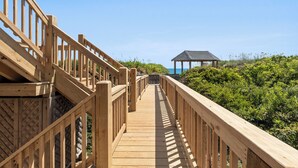 A wooden boardwalk leading to a gazebo.