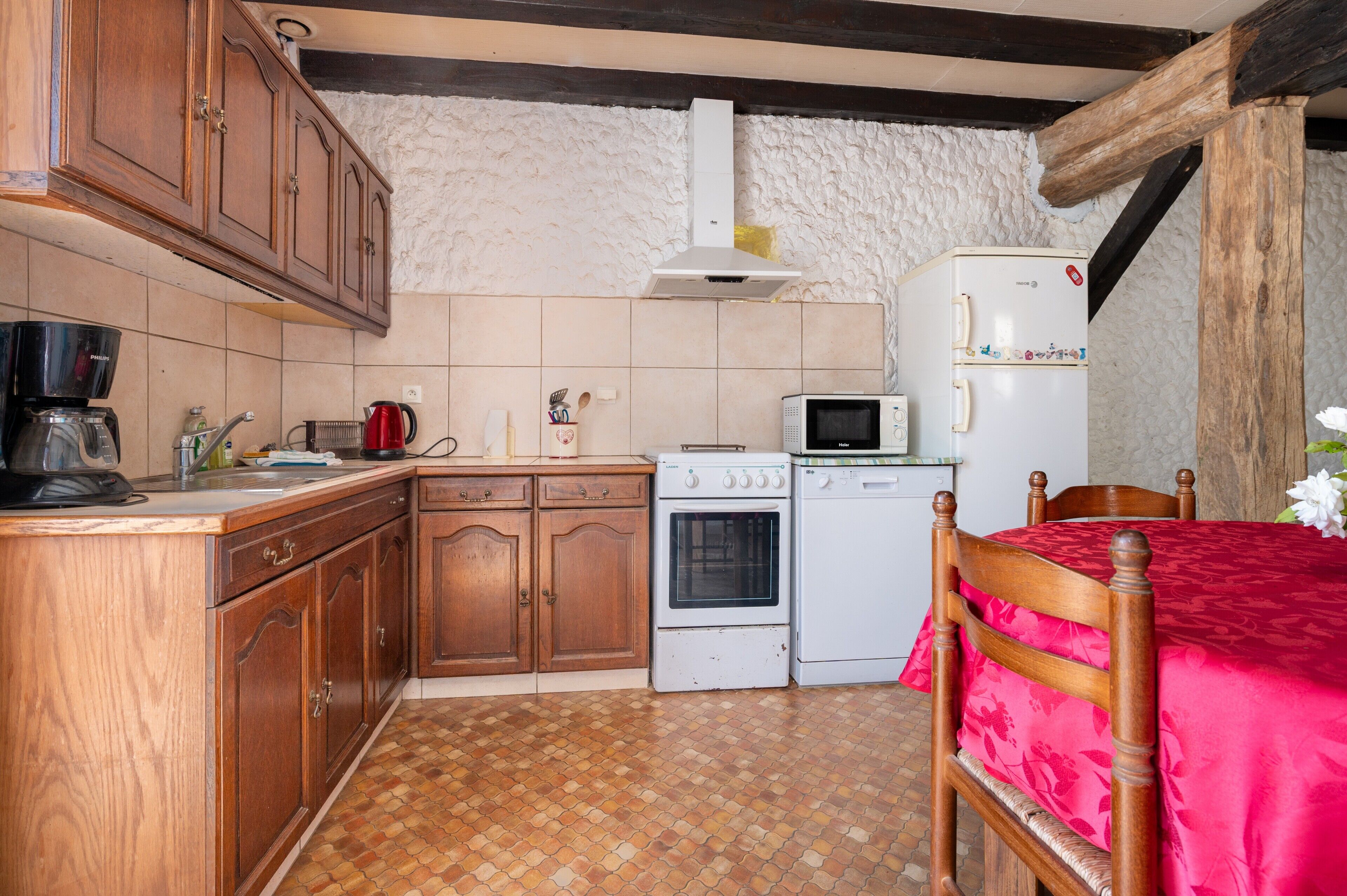 A kitchen with wooden cabinets, a stove, a microwave, and a refrigerator.