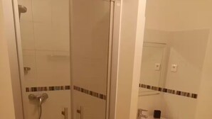 A bathroom with a glass-enclosed shower, a white sink, and a mirror above it. - Apartment 2/3 persons Laruns town center (Laruns)