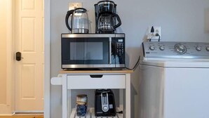 Una cocina equipada con microondas, tostadora, cafetera y estufa.