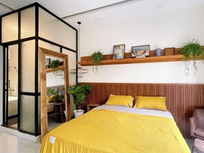 Ein modernes Schlafzimmer mit einem Bett, einem Holz-Kopfteil, einem Regal mit Pflanzen und einer Schiebetür.