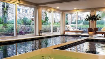 A pool area with a hot tub, large windows, and outdoor seating.