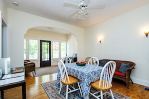 A dining area with a table set for four, a ceiling fan, and a view through an archway to a door with an American flag. - Union Pier Cottage Close To Beach! (2 Nt Min!) (Union Pier)