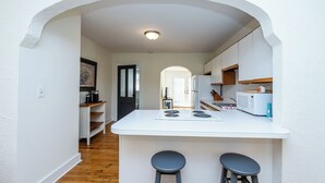 A compact kitchen with a central island, two stools, and a view into the dining area. - Union Pier Cottage Close To Beach! (2 Nt Min!) (Union Pier)