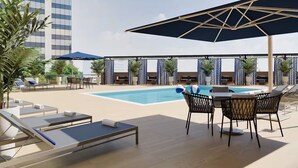 A rooftop pool area with lounge chairs, umbrellas, and a pool table. - Designer 2BR | Gym, Parking (White Plains)
