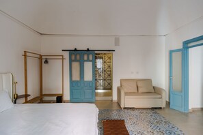 A bedroom with a bed, a sofa, a wardrobe, and a door leading to a bathroom. - Dolce Vita Central Apartment by Wonderful Italy (Catania)