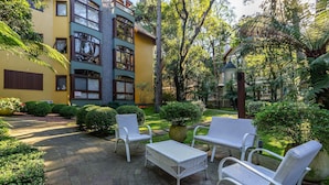 A courtyard with outdoor seating and a building with multiple windows and balconies.