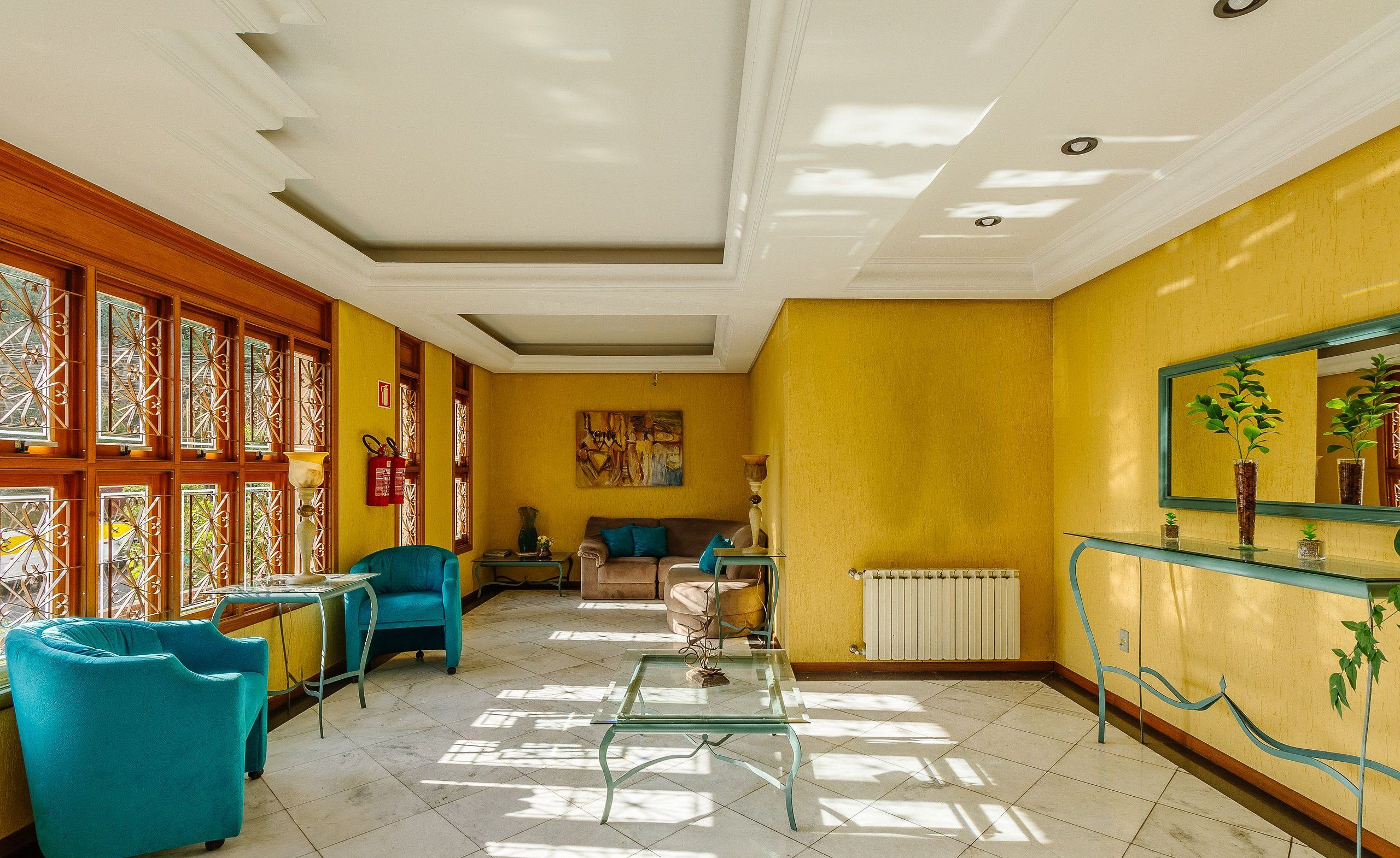 Un salon lumineux avec un canapé, des fauteuils et une table basse.
