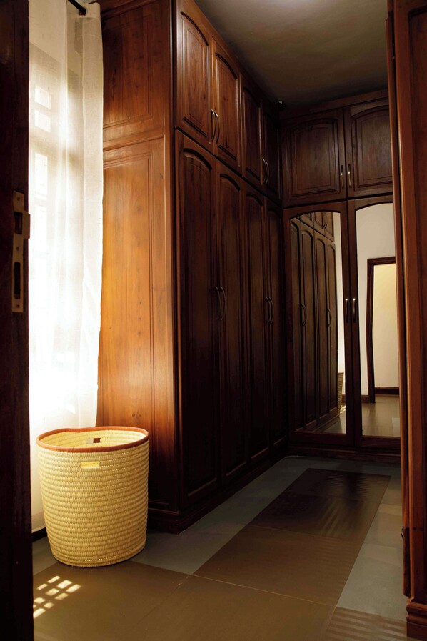 A hallway with wooden cabinets and a woven basket on the floor.