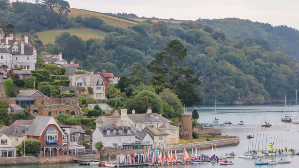 A coastal town with historic buildings, a marina with sailboats, and a hilly backdrop. - 2 The Old School House (Dartmouth)