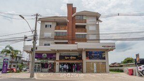 A multi-story building with a ground-level store named 'PLATZ' and a second-floor store named 'Ixy Africa'. - NSA - Apartments Close to the Center of Canela RS (Canela)