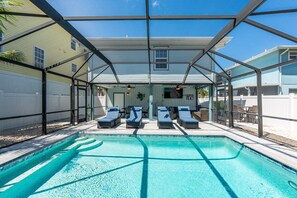 Una piscina esterna coperta con lettini e una zona prendisole.