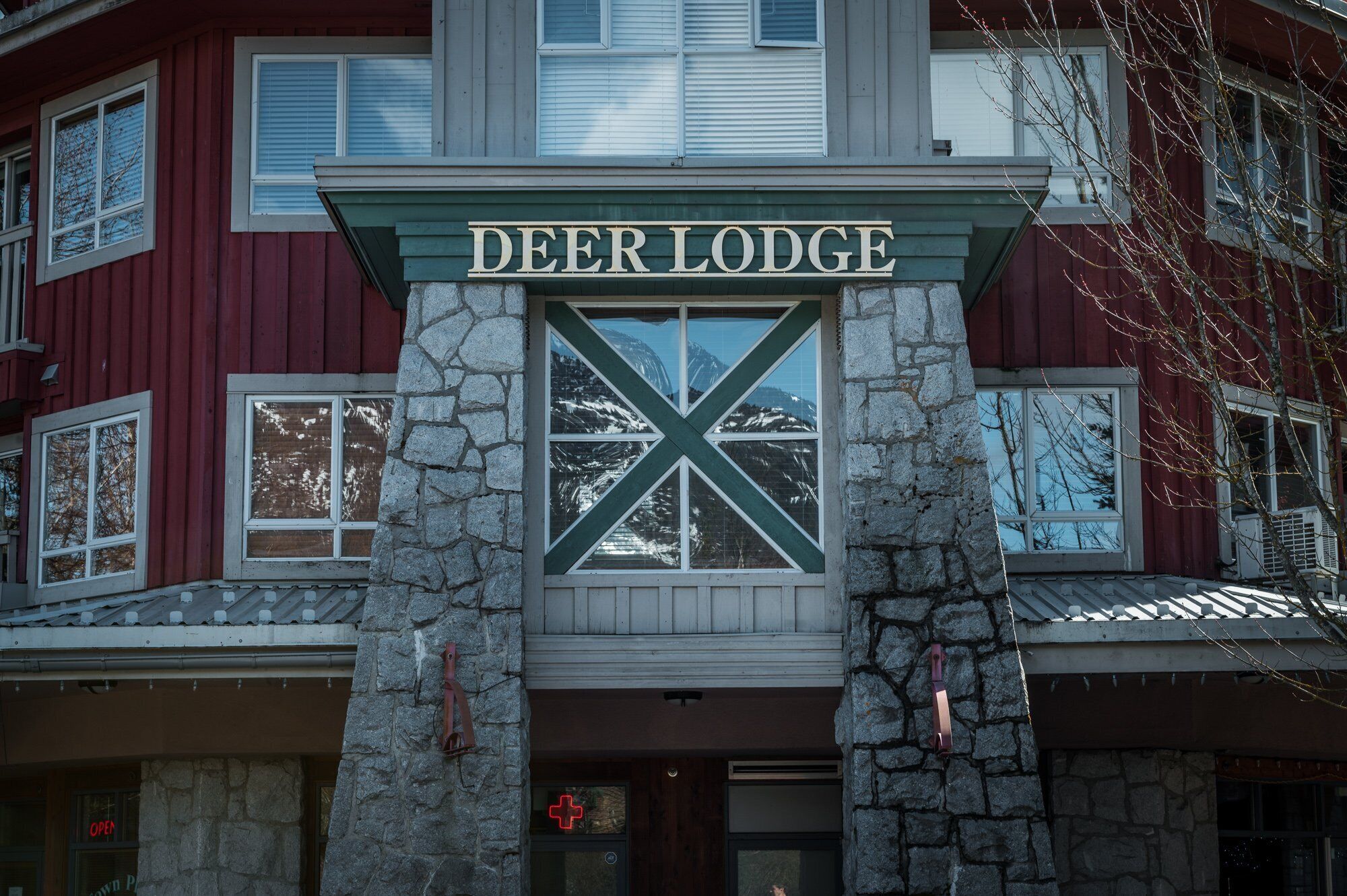 A building with a sign reading 'DEER LODGE' above a stone facade.
