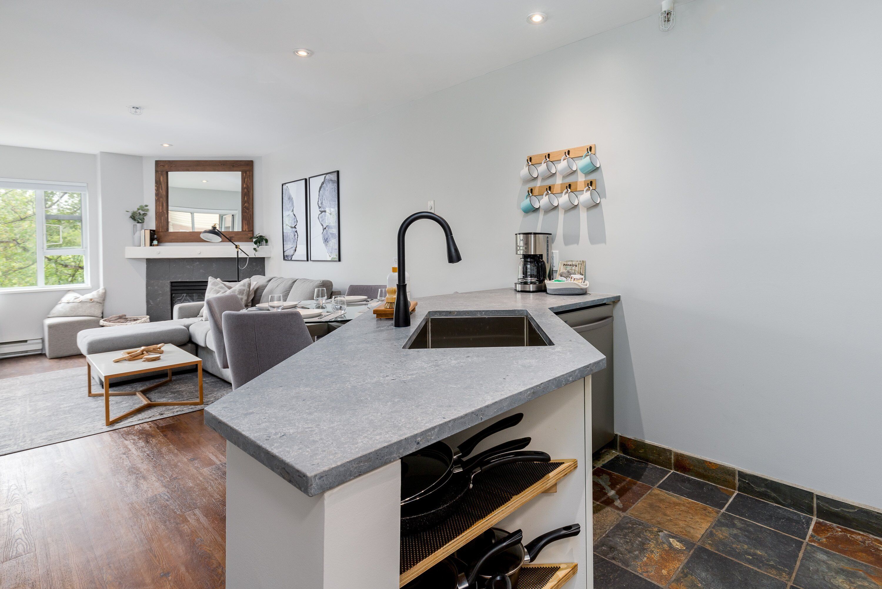 A modern kitchen with a built-in island, a dining area with a sofa, and a fireplace.