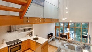 A modern kitchen with a stove, sink, and wooden cabinets. - Ridgeline Retreat at Sundance (Whistler)
