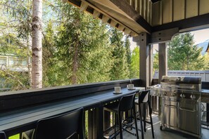 An outdoor patio with a grill, two chairs, and a table. - Summit View at The Lagoons (Whistler)