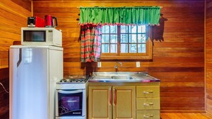 A compact kitchen with a refrigerator, microwave, stove, oven, and sink. - Santa's Cabin in Gramado Rar065 (Gramado)