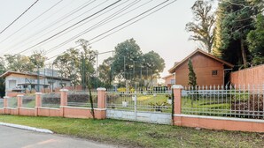 A residential area with houses, a gated fence, and a road. - Santa's Cabin in Gramado Rar065 (Gramado)