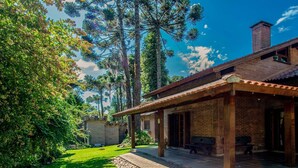 A rustic building with a brick exterior, a covered patio, and a well-maintained lawn. - Beautiful Chalet-style House in Canela Rcf160 (Canela)