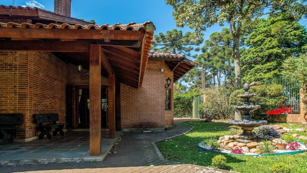 A brick building with a covered patio and a fountain in the garden. - Beautiful Chalet-style House in Canela Rcf160 (Canela)