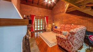 A spacious living room with a wooden staircase, a patterned sofa, and a chandelier. - Beautiful Chalet-style House in Canela Rcf160 (Canela)