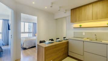 Una cocina moderna con armarios de madera, una encimera y un lavamanos. Hay un comedor con una mesa y sillas.