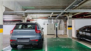 A parking garage with electric vehicle charging stations, a Volvo XC40, and a sedan. - Beautiful Apart With 2 Bedrooms in Gramado Vdb0201 (Gramado)