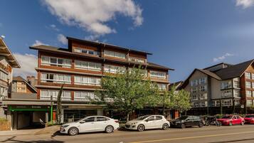 A multi-story hotel with a modern design, featuring a ground-level entrance and several balconies.