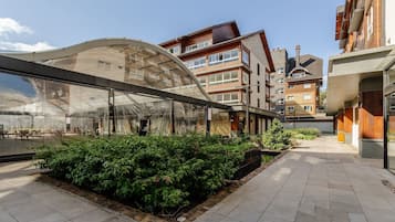 Een modern gebouw met een glazen gevel en een overdekt terras.