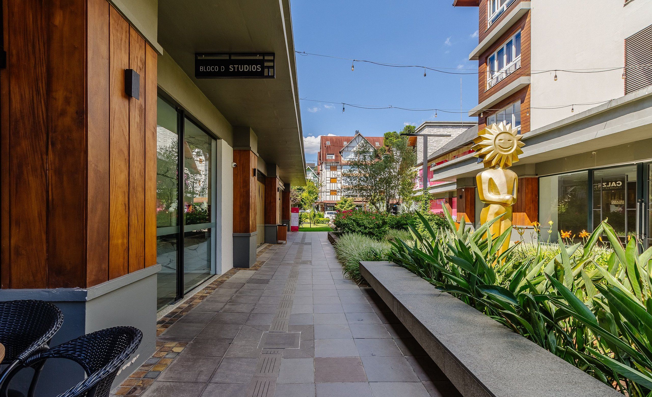 Un edificio moderno con fachada de madera, un cartel que dice 'BLOCK STUDIOS' y una escultura de sol.