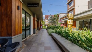 A modern building with a wooden facade, a sign for 'BLOCK STUDIOS', and a sun sculpture.