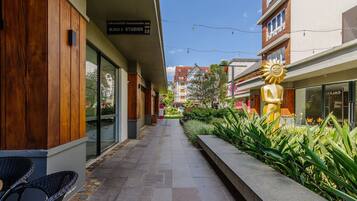 Un edificio moderno con fachada de madera, un cartel que dice 'BLOCK STUDIOS' y una escultura de sol.