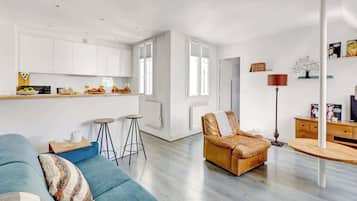 Un salon moderne avec un canapé bleu, un fauteuil en cuir et une table basse en bois.