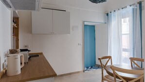 A kitchen with a coffee maker, a sink, and a blue door. - Dolce Vita Central Apartment by Wonderful Italy (Catania)