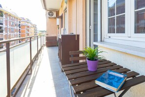 A balcony with a wooden bench, a purple potted plant, and a book titled 'DE GAULLE'. - Rental in Rome Pigneto Second Apartment (Rome)