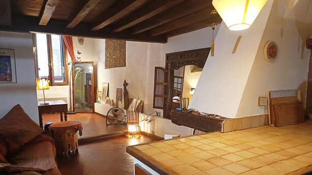 A cozy room with a wooden ceiling, a tiled floor, a sofa, a table, and various decorative items. - Loft in the heart of Nice (Nice)