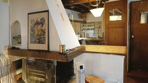 A rustic kitchen with exposed wooden beams, a large whiteboard, and a hanging light fixture. - Loft in the heart of Nice (Nice)
