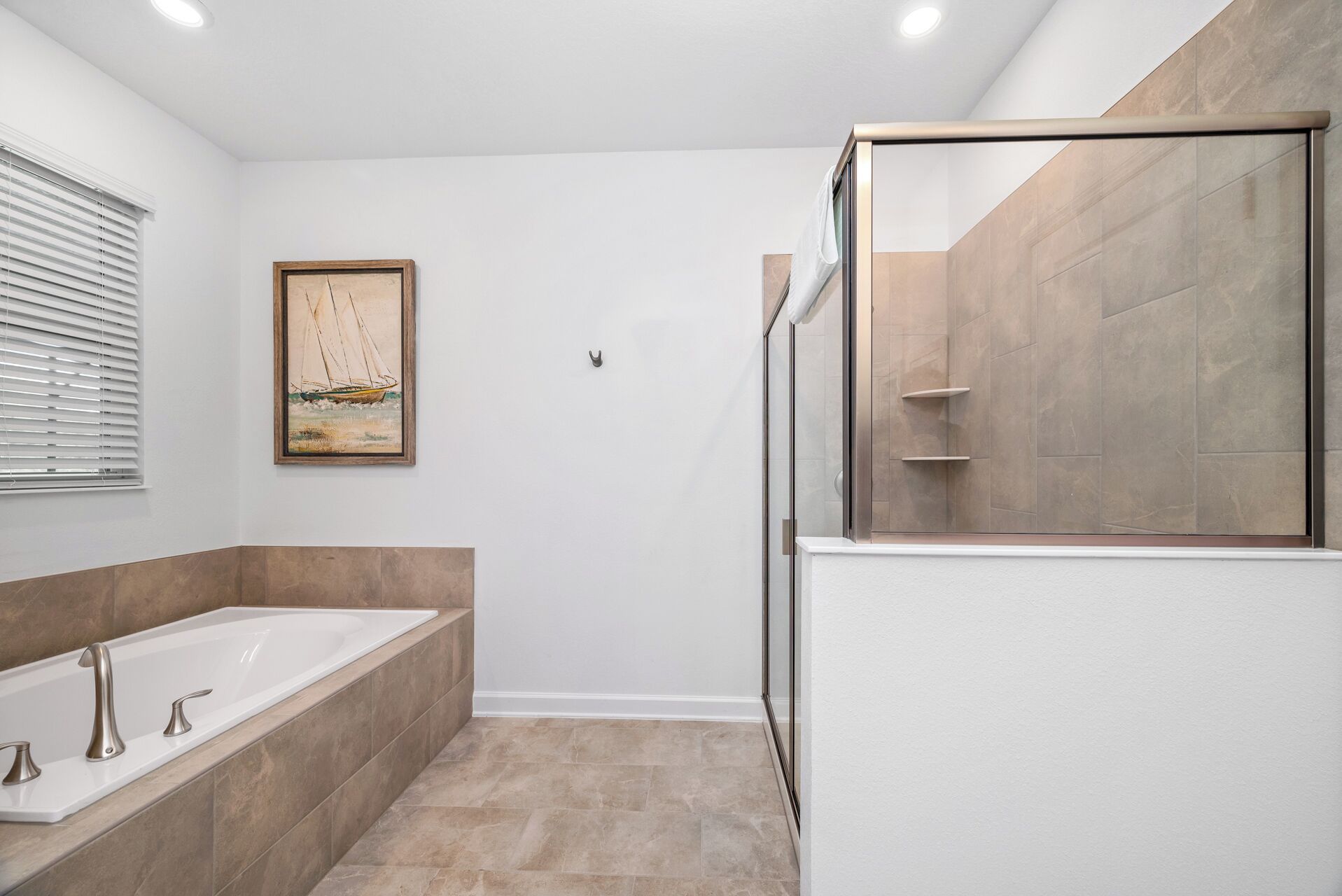 A modern bathroom with a bathtub, shower, and a glass-enclosed shower area.