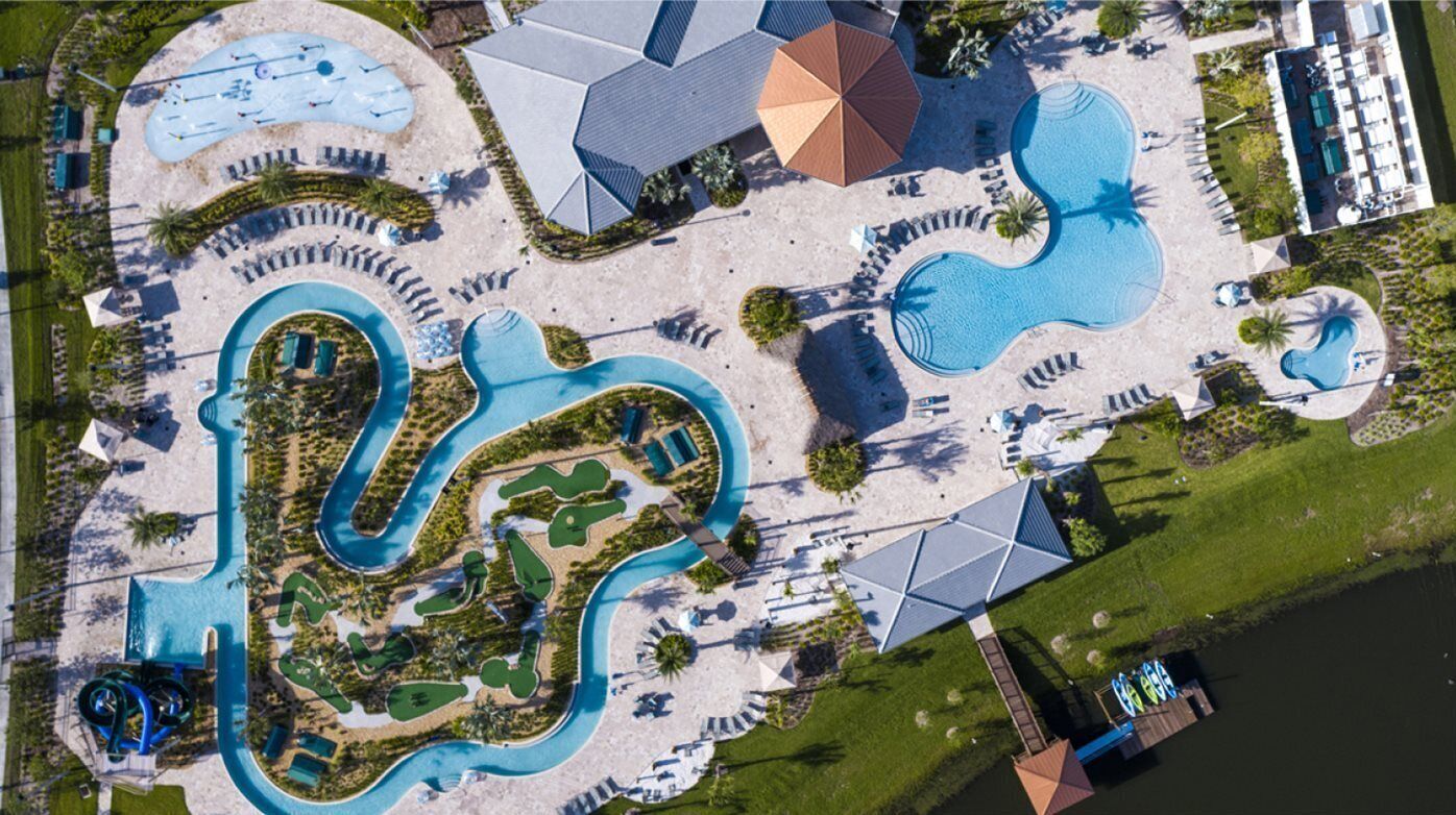 Vista aerea di un resort con diverse piscine, un grande scivolo acquatico e varie zone relax all'aperto.