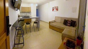 A compact living space with a kitchen, dining area, and a sofa.