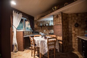 A cozy kitchen with a dining table, chairs, and a window with curtains. - Villa Blondie in Castellammare del Golfo (Castellammare del Golfo)