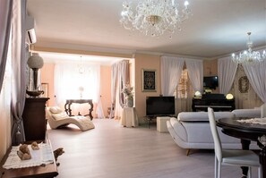 A spacious living room with a piano, a television, and a chandelier. - Villa Blondie in Castellammare del Golfo (Castellammare del Golfo)