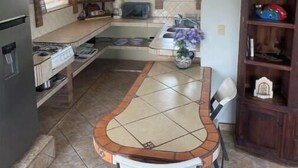 Une cuisine compacte dotée d’un îlot central, d’un réfrigérateur et d’un four à micro-ondes.