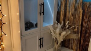 A white cabinet with glass doors, a decorative plant, and a bamboo backdrop. - Authentic 40' Hatteras Yacht 
Budget Keys Living & Ocean Views  (Key West)