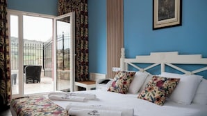 A hotel room with a bed, a desk, and a chair. There is a window with a view of the outside. - NUEVO HOTEL PARQUE CABAÑEROS (Horcajo de los Montes)