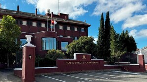 A hotel entrance with a sign reading "HOTEL PARQUE CABANEROS" and a parking lot in front. - NUEVO HOTEL PARQUE CABAÑEROS (Horcajo de los Montes)
