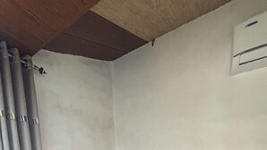 A corner room with a wooden bench, white walls, and a tiled floor. - De Soul Santé Pawna (Mawal)